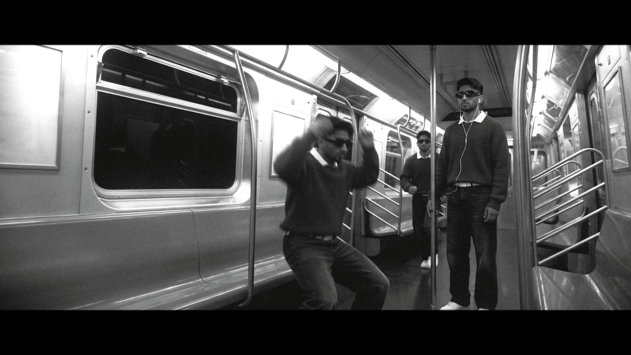 Graded still: duplicates of the character moving through an empty subway car